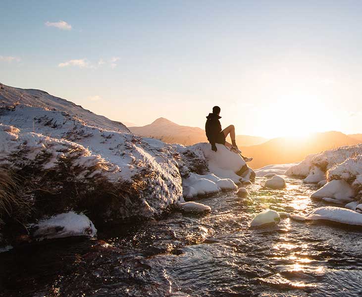 Man sitting on rock in the snow